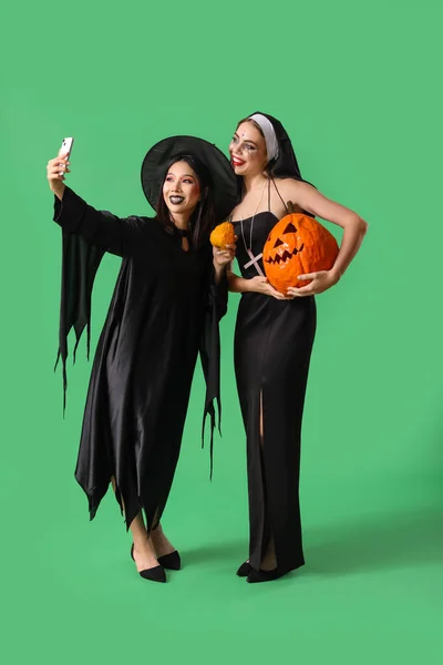 Женщины Подруги Костюмах Хэллоуин Делают Селфи Зеленом Фоне — стоковое фото
