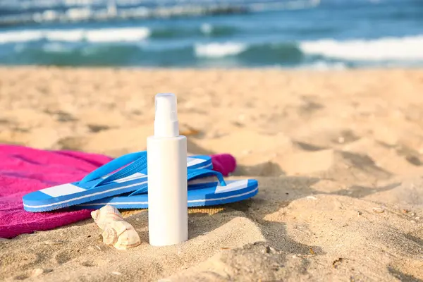 Eine Flasche Sonnencreme Flip Flops Und Handtuch Auf Sand — Stockfoto