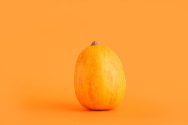 Turuncu arka planda cadılar bayramı kutlaması için ham balkabağı