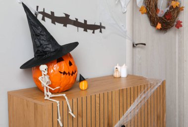 İskeletli Cadılar Bayramı balkabakları ve koridordaki klozette mumlar