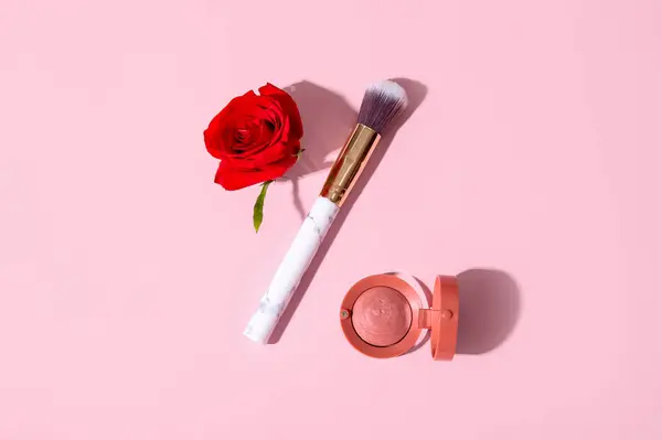 Skład Szczotką Makijażu Rumieniec Piękny Kwiat Czerwonej Róży Różowym Tle — Zdjęcie stockowe