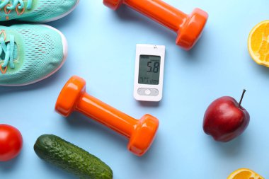 Dambılı glukometre, mavi arka planda yiyecek ve spor ayakkabı. Diyabet kavramı