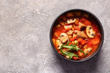 Gri arka planda bir kase lezzetli sığır güveci