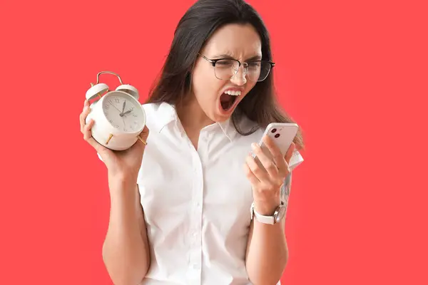 Jovem Irritada Com Despertador Telefone Celular Fundo Vermelho Conceito Limite — Fotografia de Stock
