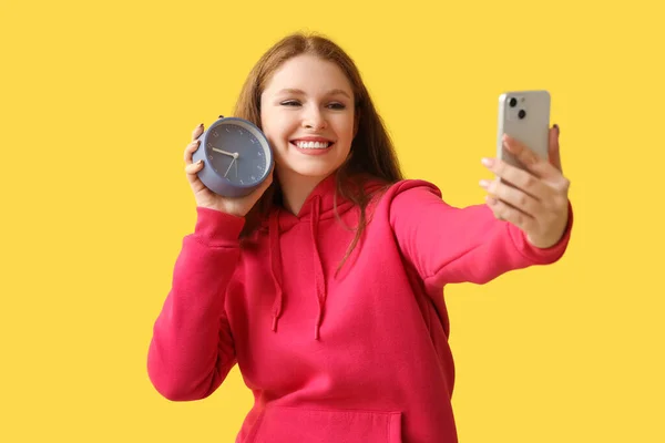 Mladá Žena Hodinami Mobilním Telefonem Selfie Žlutém Pozadí Koncept Uzávěrky — Stock fotografie