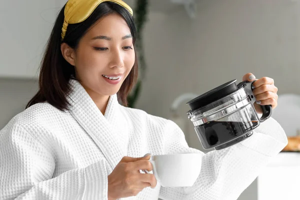 キッチンでカップにコーヒーを注ぐ美しいアジアの女性 クローズアップ — ストック写真