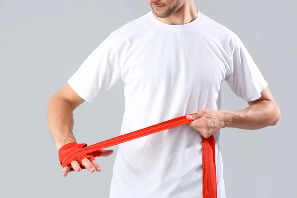 Mann Wickelt Hände Mit Rotem Verband Auf Grauem Hintergrund — Stockfoto