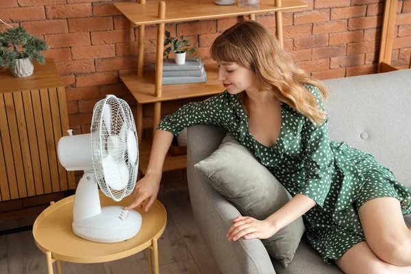 Young Woman Blowing Electric Fan Sitting Sofa Home — Stock Photo, Image