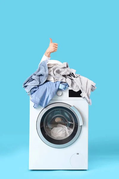 파란색 배경에 엄지손가락을 보여주는 세탁기 — 스톡 사진