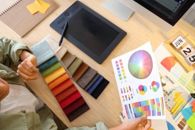 Ofisteki masada kumaş örnekleri ve renk paletleri ile çalışan kadın iç mimar, yakın plan