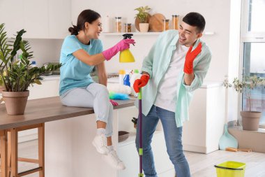 Mutfakta temizlik yapan mutlu genç çift.