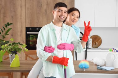 Mutfağı temizlerken kucaklaşan mutlu genç çift