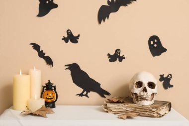 Kafatası mumlar ve Cadılar Bayramı dekoru salonda rafta.