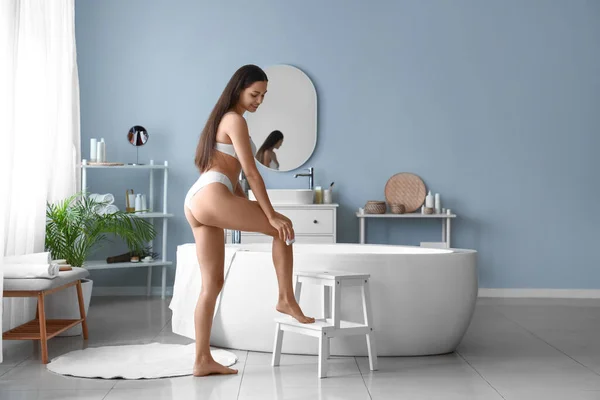 漂亮的年轻女人在浴室里用洗发水去除头发 — 图库照片