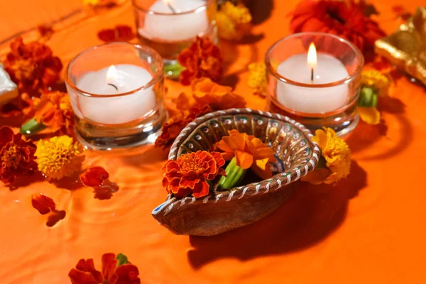 Diya Lampa Pięknymi Kwiatami Marigold Płonące Świece Wodzie Pomarańczowym Tle — Zdjęcie stockowe