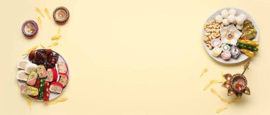 Bej arka planda Hint ikramlı tabaklar ve lambalar ve metin için yer var. Divaly kutlaması