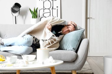 Evdeki sıcaklığı ölçen genç bir adam.