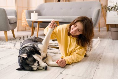 Evde köpekli mutlu genç bir kadın.