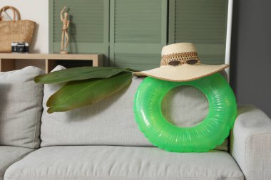 Kanepesi ve farklı plaj aksesuarları olan modern bir oturma odası.