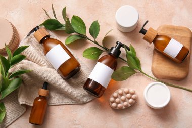 Bej arka planda şampuan şişeleri ve kozmetik ürünler