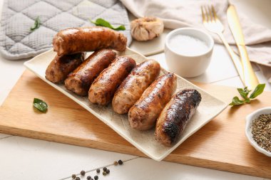 Beyaz ahşap arka planda ızgara sosis tabağı.