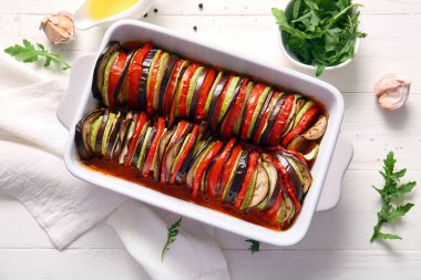 Beyaz ahşap arka planda lezzetli Ratatouille yemeği pişirmek.