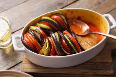 Baking dish of tasty Ratatouille on wooden background clipart