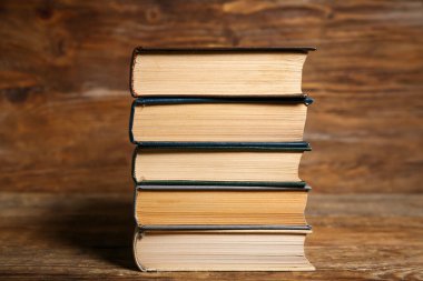 Ahşap zemin üzerine eski ciltli kitap yığını, yakın plan