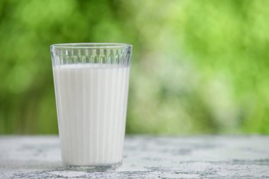 Dışarıdaki grunge masasında bir bardak taze süt.