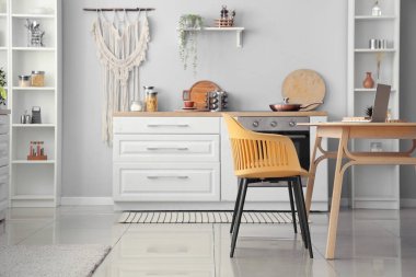 Beyaz tezgahlı ve yemek masalı aydınlık mutfağın içi.