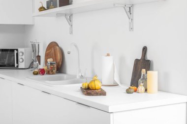 Mutfakta mutfak tezgahında mutfak malzemesi olan Cadılar Bayramı balkabakları.