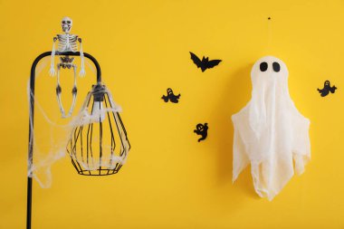 İskeletli lamba ve sarı duvarda Cadılar Bayramı dekoru