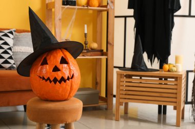 Cadılar Bayramı balkabağı ve cadı şapkası oturma odasında, yakın plan.