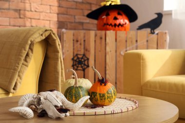 Oturma odasındaki masada üzerinde balkabağı olan keçi kafatası, yakın plan.