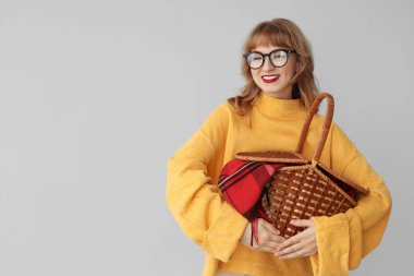 Arka planda piknik sepeti olan genç bir kadın.