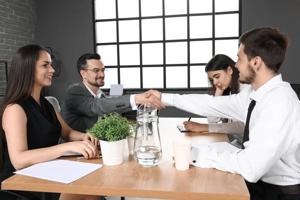 İnsan kaynakları müdürü erkek başvuru sahibi ile el sıkışıyor