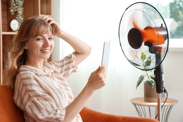 Young Woman Tablet Computer Blowing Electric Fan Sitting Sofa Home — Stock Photo, Image