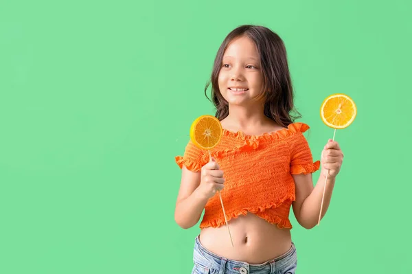 Pequeña Chica Asiática Con Rodajas Naranja Palos Sobre Fondo Verde — Foto de Stock