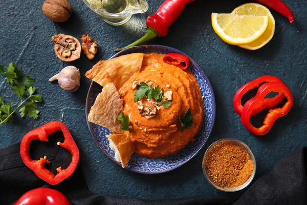 Lezzetli bir tabak muhammara ve siyah arkaplan içeriği.