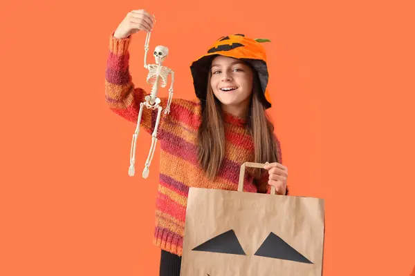 Mała Dziewczynka Szkieletem Workiem Prezentów Halloween Pomarańczowym Tle — Zdjęcie stockowe