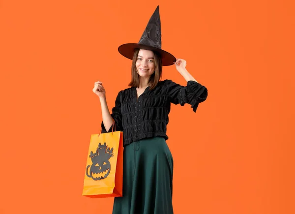 Mladá Žena Oblečená Halloween Jako Čarodějnice Dárkovým Sáčkem Oranžovém Pozadí — Stock fotografie