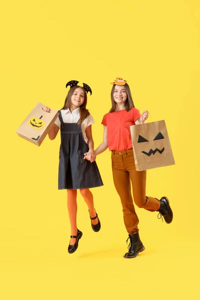 Niña Con Madre Vestida Para Halloween Con Bolsas Regalo Saltando —  Fotos de Stock
