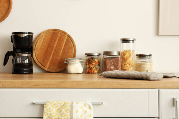Jars of food with coffee maker on counter in kitchen