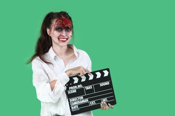 Молодая Женщина Одетая Хэллоуин Зомби Хлопающим Фильмом Зеленом Фоне — стоковое фото