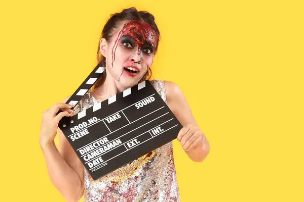 Młoda Kobieta Ubrana Halloween Jako Zombie Klapką Filmową Żółtym Tle — Zdjęcie stockowe