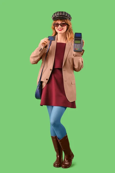 Mladá Žena Podzimním Oblečení Kreditní Kartou Platební Terminál Zeleném Pozadí — Stock fotografie