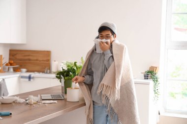 Mutfakta mendili olan Asyalı hasta bir adam.