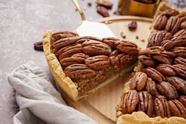 Gri arkaplanda lezzetli cevizli turta olan ahşap tahta tahta.