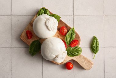 Tahta tahtada fesleğenli ve domatesli leziz Burrata peyniri var.