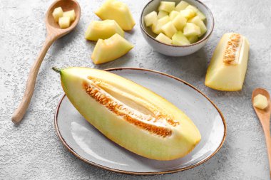 Beyaz arka planda tatlı kavun parçaları olan tabak ve tabak.